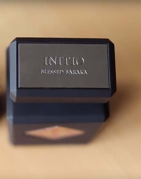 A close-up of the brand’s name and the name of the scent engraved on the top of the cap of a bottle of Initio Parfums Prives Blessed Baraka.