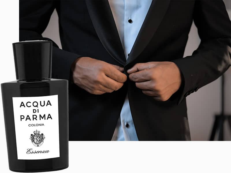 A bottle of Acqua Di Parma Colonia Essenza depicted next to a man’s torso wearing a tuxedo.