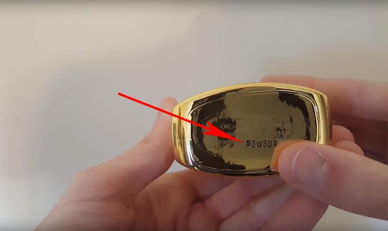 A red arrow pointing to the location of the batch code on the base of a bottle of Parfums de Marly Godolphin.