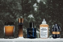 a selection of 5 of the best winter cologne bottles from 5 different brands lined up in the snow.
