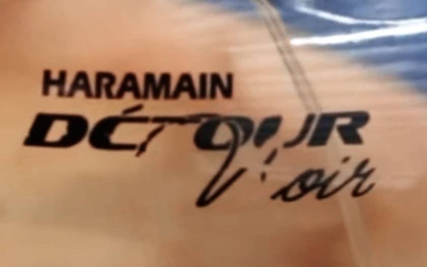 A close-up of the partially rubbed-off lettering on the front of an Al Haramain Detour Noir bottle.