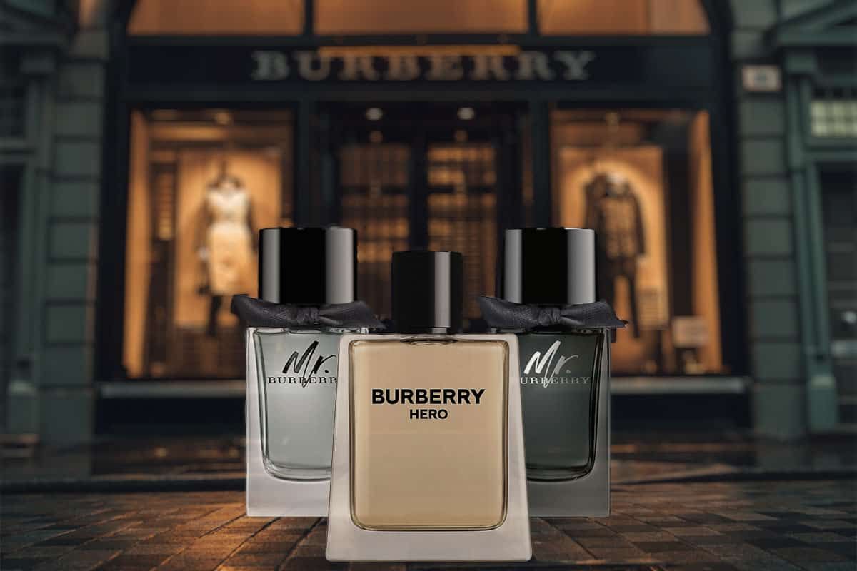 3 different Burberry cologne bottles on the sidewalk in front of a Burberry storefront.