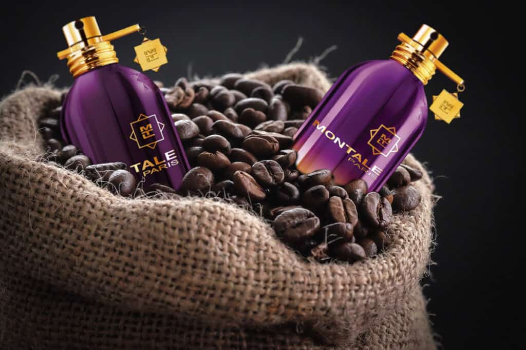 A bottle of Montale’s Intense Café and Ristretto Intense Café protruding out the top of a sack of roasted coffee beans.