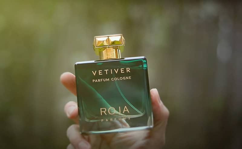 A close-up of a bottle of Roja Parfums Vetiver Parfum Cologne being held in right hand.