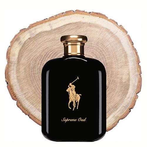 A bottle of Ralph Lauren Polo Supreme Oud in front of the fresh cut end face of an oud wooden log.