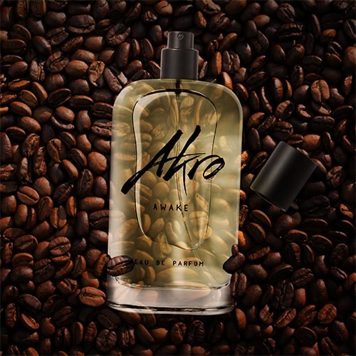 A bottle of Akro Awake placed faceup on top of a pile of dark roasted coffee beans.