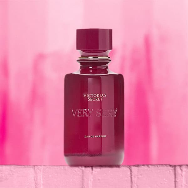 A close-up of the new, updated Victoria’s Secret Very Sexy EDP bottle. The bottle is sitting on top of a light pink colored brick wall.