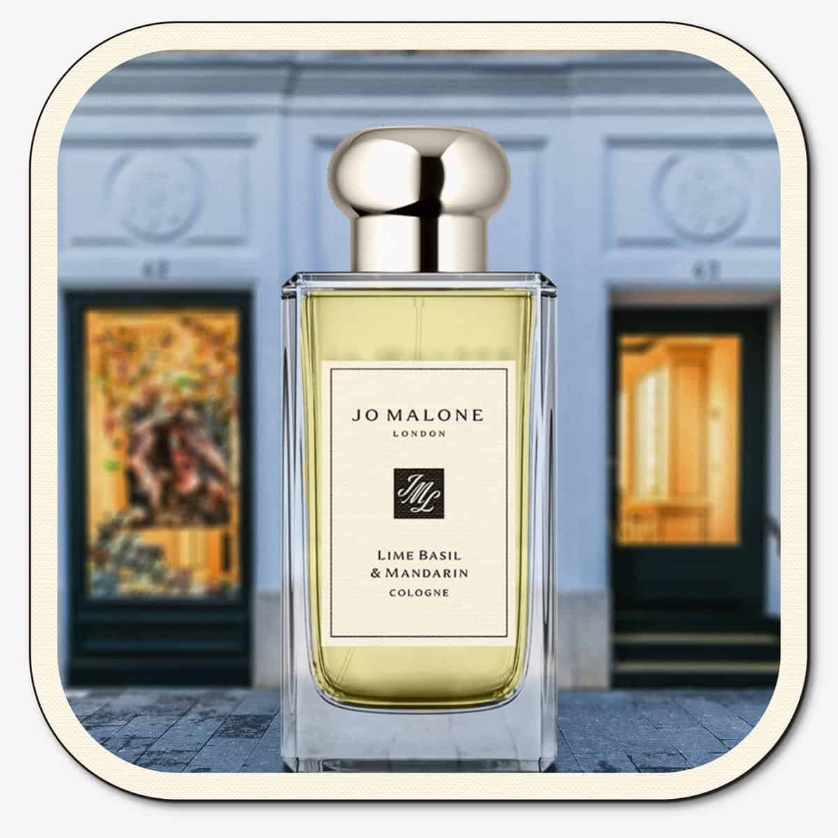 A close-up of the front face of a bottle of Jo Malone Lime Basil & Mandarin Cologne. The bottle is placed on the ground with the Jo Malone global flagship storefront in 
London in the background.