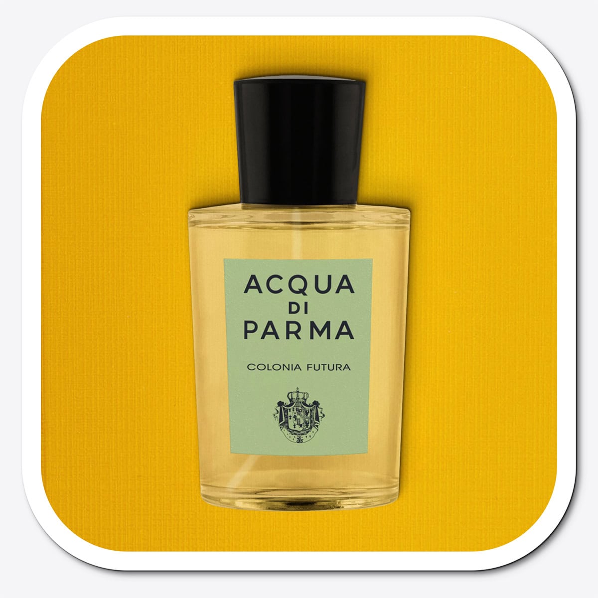 A close-up of the front face of a bottle of Acqua Di Parma Colonia Futura. The bottle is placed on its side, label side up, and is resting on a yellow-colored textured surface.